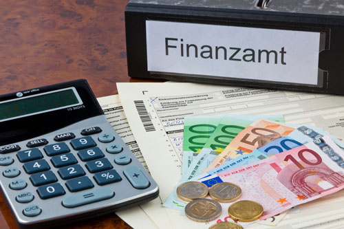 Beitragsbild zeigt Schuber für Finanzamt, Geld und Taschenrechner sowie Formularen